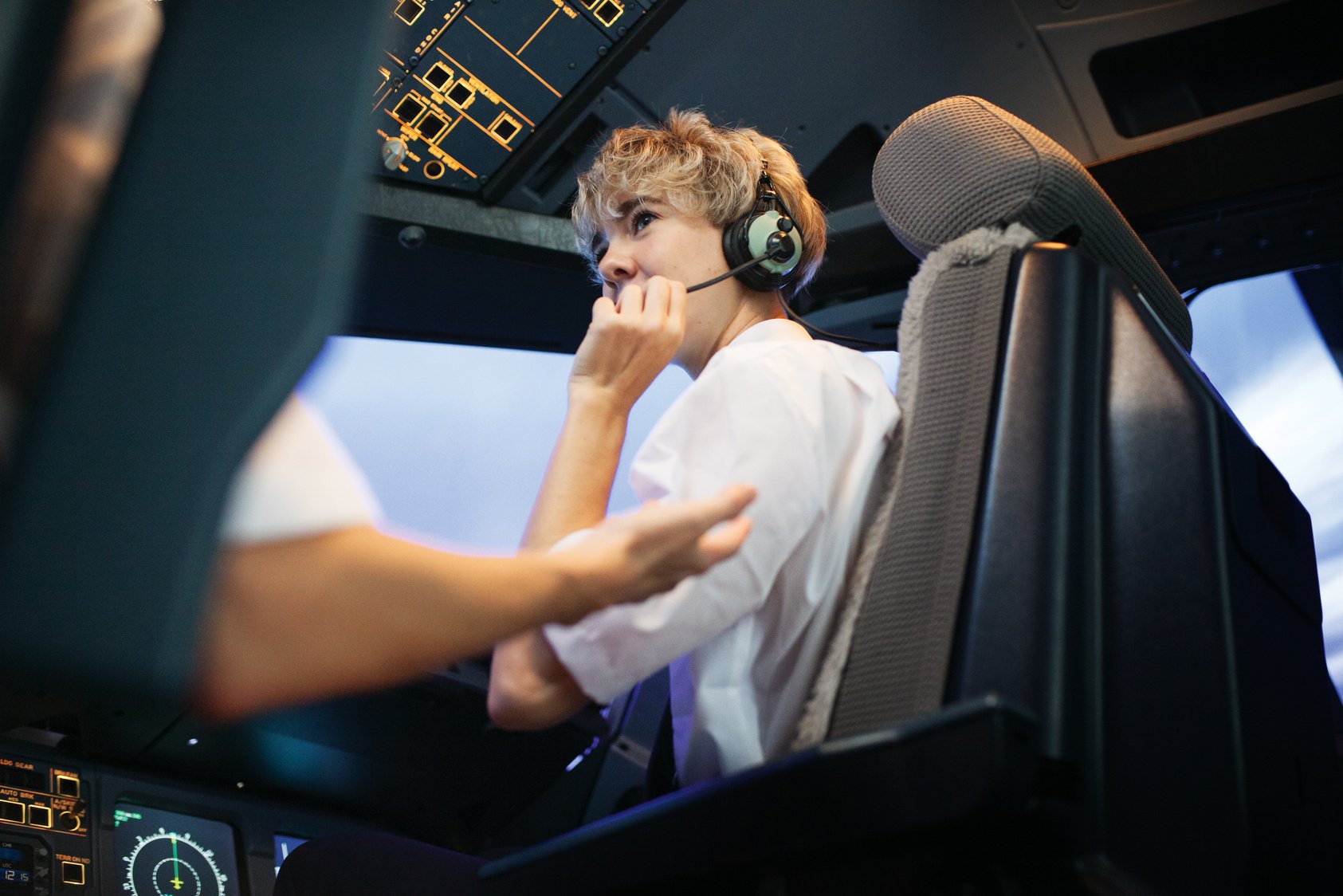 Trainee Pilot With Headphones On During Flight Simulator Training